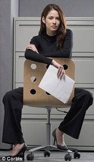 A businesswoman sits on a chair with a sheet of paper in her hand